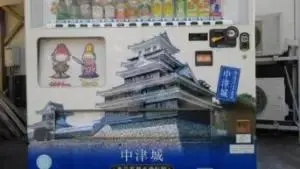 alt="中津城の自動販売機に描かれている「おっくん」"