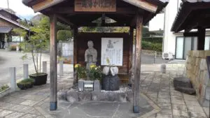 alt="体の悪い部分に温泉の湯をかけて治癒を願う「一遍上人の像」"