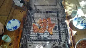 alt="炭火で香ばしく焼いている阿蘇地鶏"