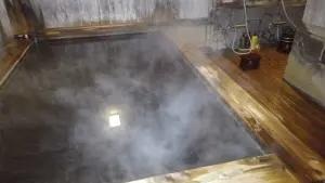 alt="湯気が立ち上がる露天風呂”