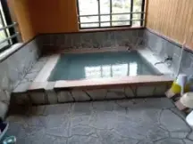 alt="湯の花が舞う「真っ白な濁り湯」の豊前屋旅館”